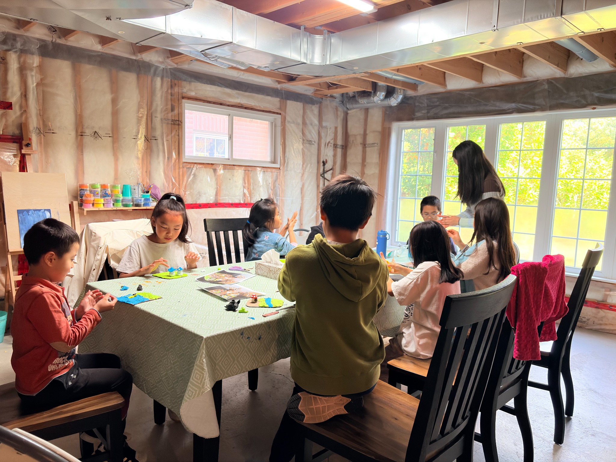 Children and volunteers gathered around the table at the Create Your Own World workshop