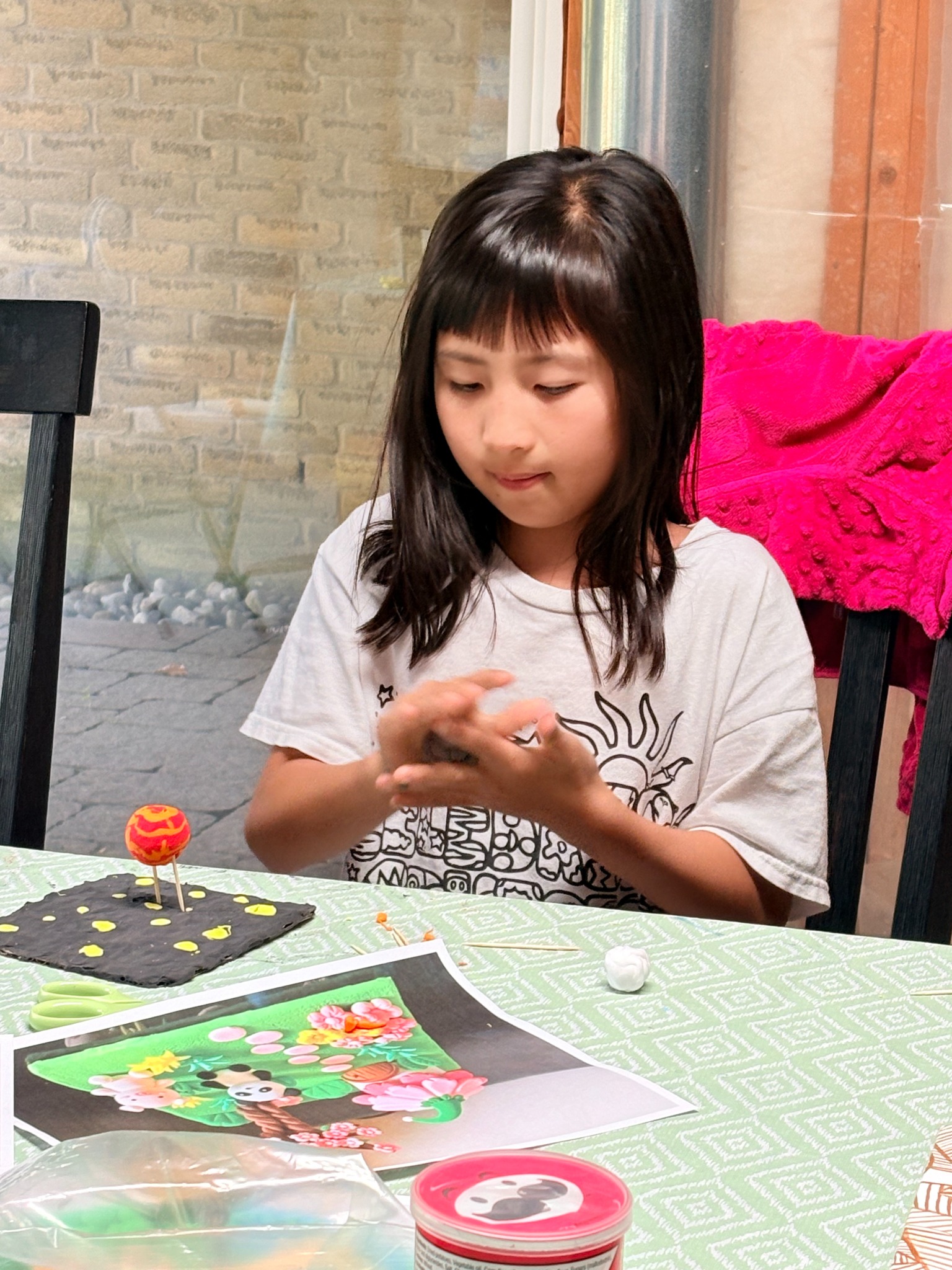 A child creating clay details for an imaginative miniature world